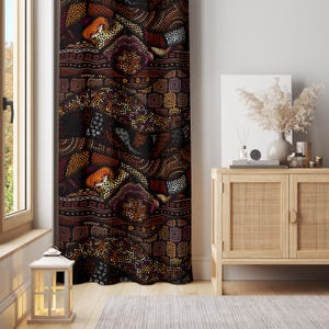 May include: A patterned curtain with a dark background and a repeating design in shades of brown, orange, and yellow. The design includes geometric shapes and dotted patterns. The curtain is hanging in front of a window.