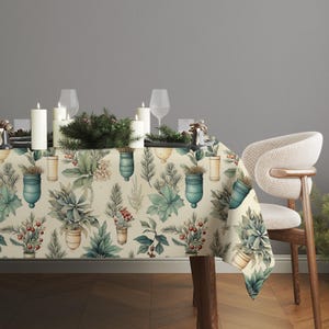 Peut inclure: Une nappe beige avec un motif botanique à l'aquarelle représentant des pots turquoise, des feuilles vertes et des baies rouges. La table est dressée avec des bougies blanches, des verres à vin et une couronne décorative.