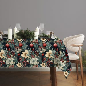 May include: A Christmas-themed tablecloth featuring a dark navy backdrop with a repeating pattern of red baubles, cream and white flowers, green foliage, and red berries. The table is set with candles, glasses, and a chair.