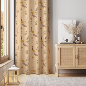 May include: Beige curtain with a repeating pattern of stylized yellow birds, brown wings, and geometric shapes. The curtain hangs in front of a window, with a wooden cabinet and decorative items in the background. The overall theme is home decor.