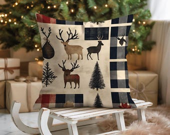 May include: A square cushion with a beige backdrop, adorned with deer silhouettes, Christmas trees, and red, black, and white plaid patterns. The cushion rests on a white wooden sledge, with a Christmas tree and wrapped gifts in the background.