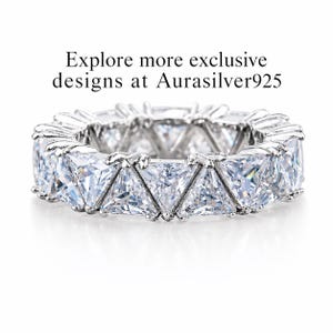 Puede incluir: Un anillo de plata con una banda continua de piedras preciosas claras talladas en forma triangular. El dise&ntilde;o del anillo presenta una serie de piedras brillantes y muy juntas. El texto en la imagen dice: Explora m&aacute;s dise&ntilde;os exclusivos en Aurasilver925.