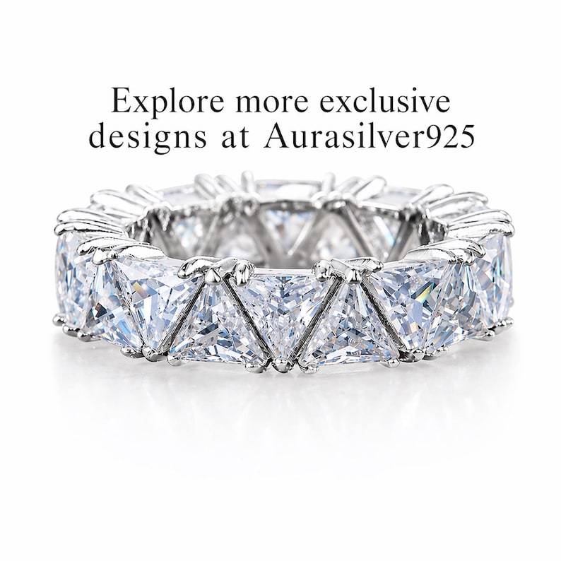 Puede incluir: Un anillo de plata con una banda continua de piedras preciosas claras talladas en forma triangular. El dise&ntilde;o del anillo presenta una serie de piedras brillantes y muy juntas. El texto en la imagen dice: Explora m&aacute;s dise&ntilde;os exclusivos en Aurasilver925.