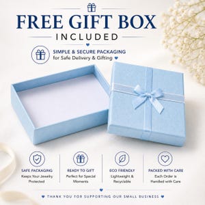 Puede incluir: Una caja de regalo azul claro con una cinta y lazo a juego, junto a una caja abierta. El texto dice "FREE GIFT BOX INCLUDED" y "SIMPLE & SECURE PACKAGING for Safe Delivery & Gifting". Texto adicional destaca embalaje seguro, listo para regalar, ecol&oacute;gico y embalado con cuidado.