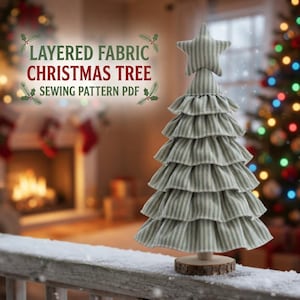 Peut inclure: Un sapin de Noël décoratif en tissu avec des étages à volants superposés dans un motif rayé vert et blanc, surmonté d'une étoile en tissu assortie. La base est une pièce de bois naturel circulaire. Le texte indique : LAYERED FABRIC CHRISTMAS TREE SEWING PATTERN PDF.