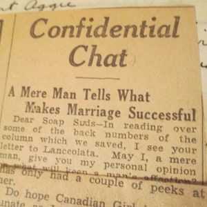 May include: A close-up of a vintage newspaper clipping with the headline "Confidential Chat." The article, titled "A Mere Man Tells What Makes Marriage Successful," is printed in black ink on aged, yellowed paper. Handwritten notes are visible in the margins.