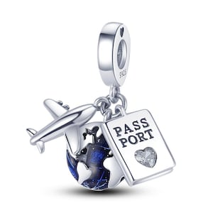 May include: A silver charm featuring a small airplane, a globe with blue and white accents, and a passport with the word "PASSPORT" and a heart-shaped gem. The charm is designed for a bracelet or necklace.