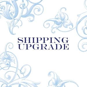 May include: A white background with blue floral designs in the corners. The text "SHIPPING UPGRADE" is in the centre of the image in a dark blue font.