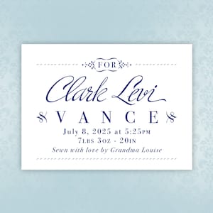 May include: White card with blue text announcing the birth of Clark Levi Vance. The card includes the date and time of birth, weight, length, and a message saying "Sewn with love by Grandma Louise".
