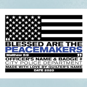 May include: Black and white American flag with a blue stripe across the middle. The text "Blessed are the Peacemakers" is written in white with a blue quote mark on each side. The text "Matthew 5:9" is written in black below the quote. The text "Officer's Name & Badge # City Police Department Made with Love by Quilter's Name Date 2020" is written in black below the scripture.