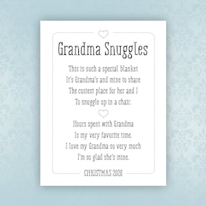 May include: A white card with black text that reads "Grandma Snuggles". The text says "This is such a special blanket. It's Grandma's and mine to share. The coziest place for her and I to snuggle up in a chair. Hours spent with Grandma is my very favorite time. I love my Grandma so very much. I'm so glad she's mine. CHRISTMAS 2026".
