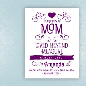 May include: A white card with a purple heart and text that reads "in memory of MOM LOVED BEYOND MEASURE MEMORY QUILT for Amanda MADE WITH LOVE BY MICHELLE WILSON • SUMMER 2024."