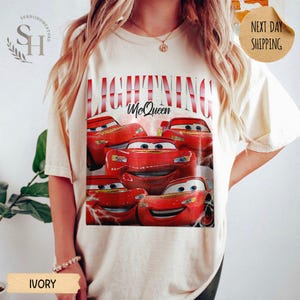 Puede incluir: Camiseta de color marfil con un dise&ntilde;o de Rayo McQueen de la pel&iacute;cula Cars. El dise&ntilde;o incluye m&uacute;ltiples im&aacute;genes del coche de carreras rojo con el texto "LIGHTNING McQueen" en rojo. La camiseta tiene cuello redondo y mangas cortas.