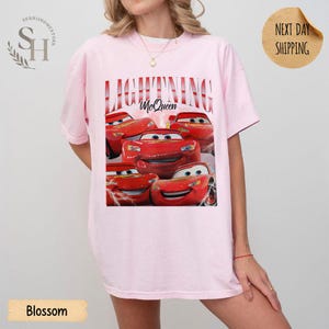 Puede incluir: Camiseta rosa claro con un dise&ntilde;o de Rayo McQueen de la pel&iacute;cula Cars. El dise&ntilde;o incluye el texto "LIGHTNING McQueen" en rojo. La camiseta tiene un corte holgado y extragrande.