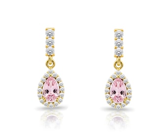 May include: A pair of gold-coloured drop earrings. Each earring features a pear-shaped, light pink gemstone surrounded by a halo of small, clear stones. A vertical row of clear stones adorns the top portion of each earring.