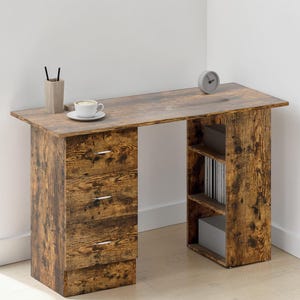 May include: A wooden desk with a distressed brown finish. The desk has three drawers on one side and open shelving on the other. A cup of coffee, a pen holder, and a small clock are on the desk surface.