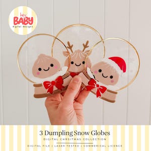 Può includere: Tre ornamenti circolari in acrilico a forma di palla di neve con simpatici personaggi a forma di raviolo. Un raviolo ha le corna da renna, un altro indossa un cappello da Babbo Natale e tutti hanno fiocchi rossi. Finitura glitterata e bordi dorati.