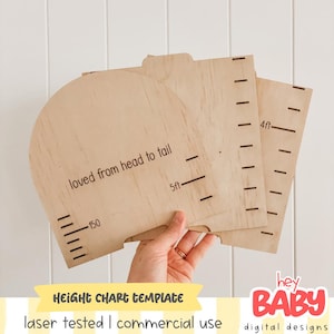 Puede incluir: Un conjunto de tres plantillas de madera clara para medir la altura con marcas cortadas a láser. Las piezas incluyen texto impreso en negro que dice "loved from head to tail", "5ft" y "4ft", junto con varias líneas de medición.