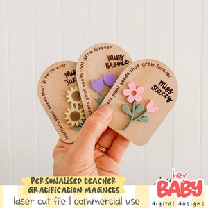May include: Three wooden teacher appreciation magnets with floral designs and personalized names. Each magnet features a different flower: sunflowers, purple tulips, and a pink flower. The magnets have the text "teachers plant seeds that grow forever".