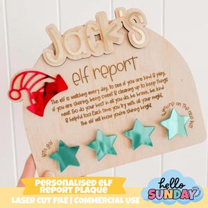 May include: A wooden elf report plaque, personalised with the name "Jack's" in gold. It features a red elf hat, four teal star accents, and text about good behavior. The plaque reads "Personalised Elf Report Plaque" at the bottom.