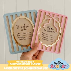 May include: Two vintage baby announcement plaques. One is light blue with a gold oval frame, the other is pink with a gold scalloped frame and bow. Both have space for baby's name, date, time, weight, and length.