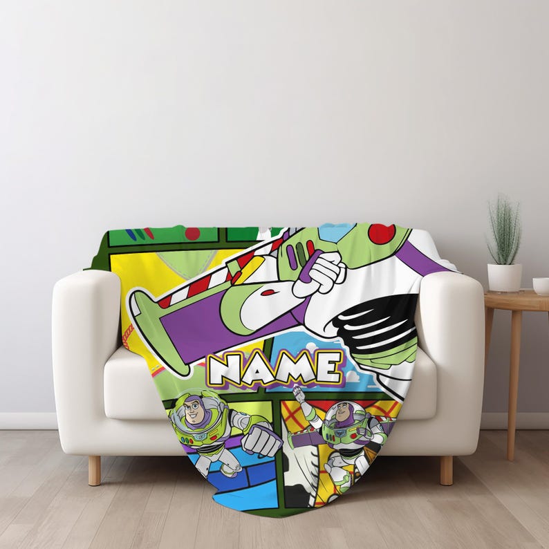 Puede incluir: Una manta de forro polar suave con un estampado gr&aacute;fico colorido del personaje Buzz Lightyear en varias poses de acci&oacute;n. El dise&ntilde;o incluye un esquema de colores amarillo, blanco y morado con la palabra NAME impresa en letras blancas.