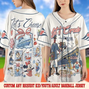 May include: White baseball jersey with a navy blue collar and button closure. The jersey features a cruise ship design with the text "Let's Cruise" and various Disney characters. The text "DREAM 2026" is also visible.