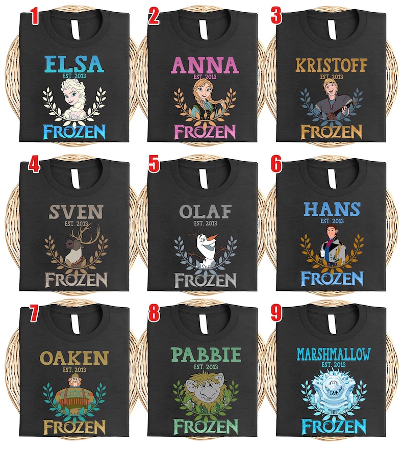 Puede incluir: Nueve camisetas negras con personajes de "Frozen". Cada camiseta muestra el nombre de un personaje, "EST. 2013" y "FROZEN". Los personajes incluyen a Elsa, Anna, Kristoff, Sven, Olaf, Hans, Oaken, Pabbie y Marshmallow.