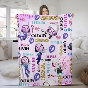 May include: A light pink fleece blanket featuring a repeating pattern of Ghost-Spider characters in various poses, pink spider web graphics, and the name Olivia printed in multiple fonts, colors, and orientations across the entire fabric surface.
