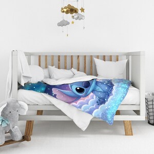 Puede incluir: Una manta suave con un estampado gr&aacute;fico vibrante del personaje azul Stitch de Lilo y Stitch, representado descansando sobre nubes estilizadas de color morado y azul contra un fondo de cielo nocturno estrellado con acentos de luz.