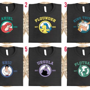 Puede incluir: Seis camisetas negras con diferentes dise&ntilde;os de personajes de La Sirenita. Cada camiseta presenta un nombre de personaje, un gr&aacute;fico y el a&ntilde;o "1989". Los personajes incluyen Ariel, Flounder, Rey Trit&oacute;n, Eric, &Uacute;rsula y Flotsam.