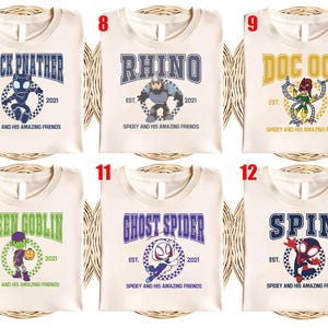 May include: Cream-colored t-shirts featuring various superhero designs. Each shirt displays a character's name in a collegiate font, along with an illustration and the text "Spidey and His Amazing Friends".