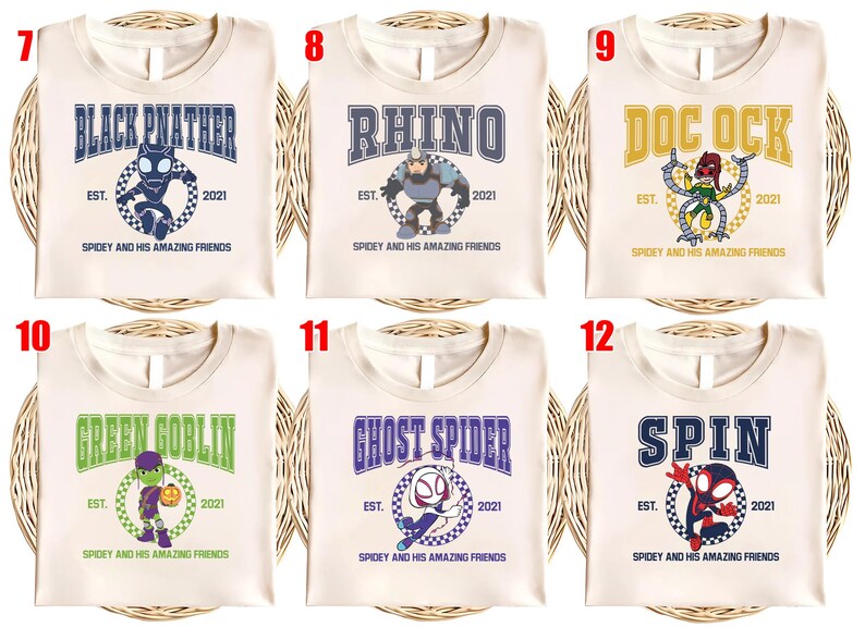 May include: Cream-colored t-shirts featuring various superhero designs. Each shirt displays a character's name in a collegiate font, along with an illustration and the text "Spidey and His Amazing Friends".