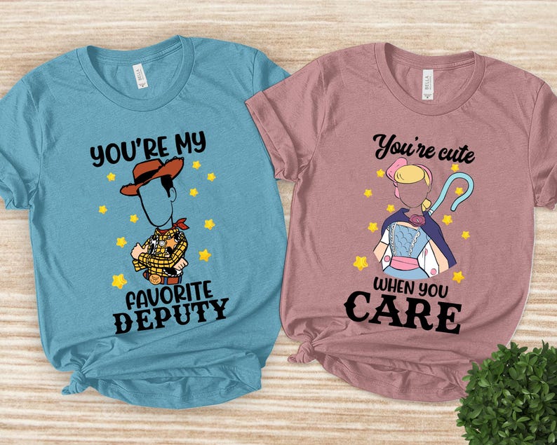 May include: Two t-shirts, one light blue and one mauve, with cartoon graphics. The light blue shirt says "You're my favorite deputy" with a Woody character. The mauve shirt says "You're cute when you care" with a Bo Peep character.