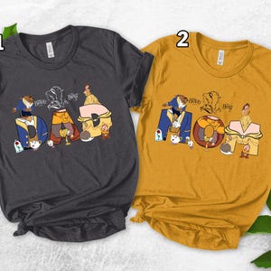 May include: Two t-shirts, one dark gray and one mustard yellow, each featuring a graphic design. The design spells out "DAD MOM" with characters from Beauty and the Beast. The shirts are short-sleeved and have a crew neck.