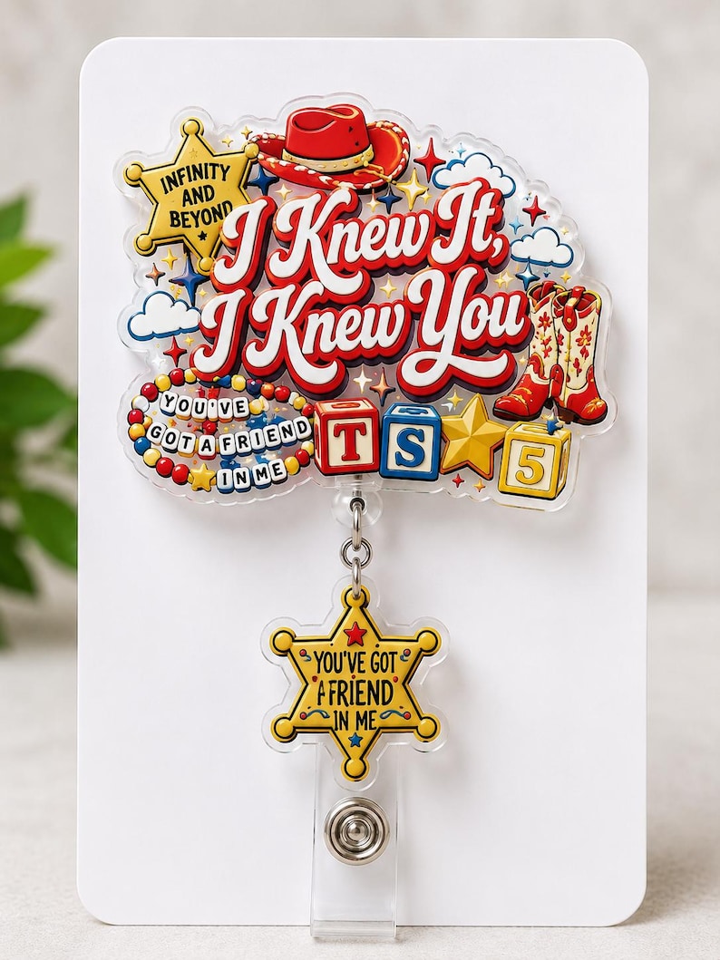 Puede incluir: Un portatarjetas de acr&iacute;lico con un dise&ntilde;o colorido que incluye un sombrero de vaquero rojo, botas, bloques de letras y estrellas. El texto dice I Knew It, I Knew You, Infinity And Beyond y You've Got A Friend In Me en un dije de estrella.