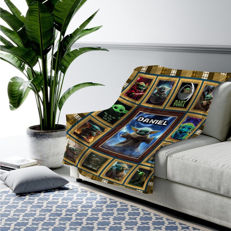 May include: A rectangular throw blanket featuring a grid of framed images of the character Grogu, also known as Baby Yoda, in various poses. The center frame is larger and displays the name DANIEL in white text above a central image of the character.
