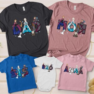 Puede incluir: Una colecci&oacute;n de camisetas y un body con las palabras "DAD", "MOM", "SIS", "BRO" y "ANNA" en una fuente colorida y estilizada. Cada dise&ntilde;o incluye ilustraciones de personajes de una popular pel&iacute;cula de animaci&oacute;n. Las camisetas son de varios colores.