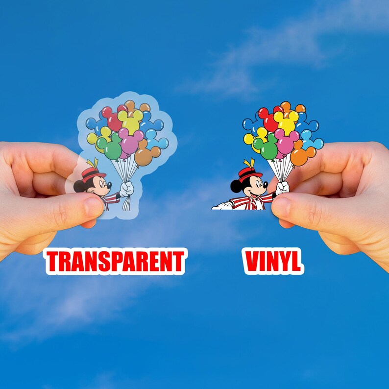 May include: Two stickers featuring Mickey Mouse holding colorful balloons. One is transparent, the other is vinyl. The text "TRANSPARENT" and "VINYL" are displayed below each sticker against a blue sky background.