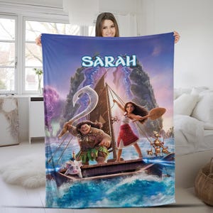 May include: A rectangular fleece blanket featuring a vibrant Moana-themed graphic with the name Sarah printed in blue at the top. The design depicts Moana and Maui on a wooden sailing boat on the ocean, accompanied by Pua and Heihei characters.