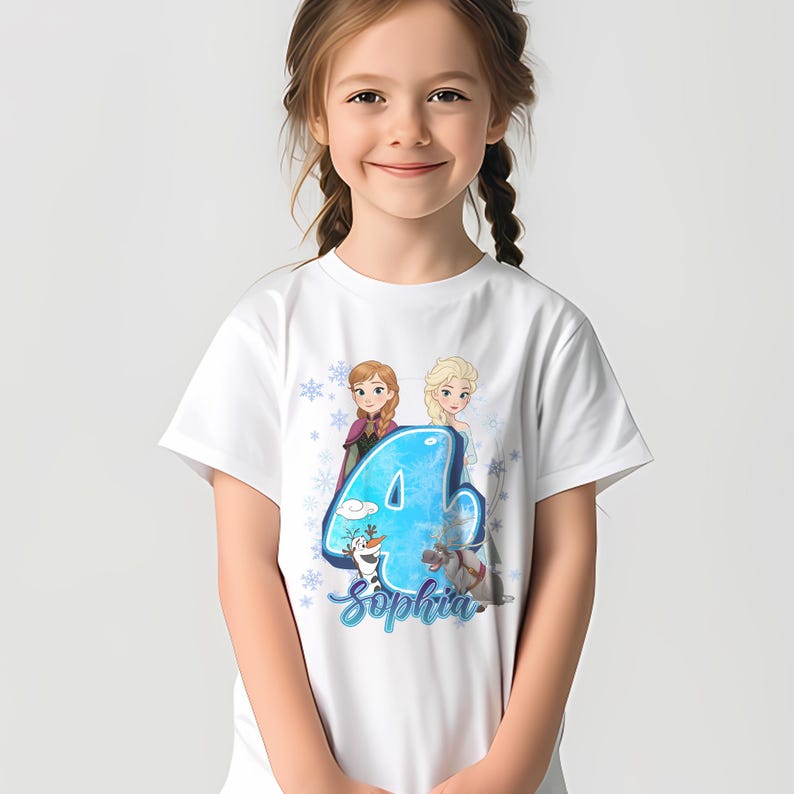 Pode incluir: T-shirt branca com um gr&aacute;fico colorido do n&uacute;mero 4, com as personagens Anna e Elsa do filme Frozen. A t-shirt tamb&eacute;m inclui o nome "Sophia" em uma fonte cursiva.