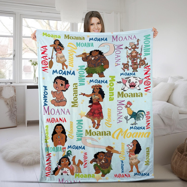May include: A light blue fleece blanket featuring a repeating pattern of Moana characters including Moana, Maui, Pua the pig, and Heihei the rooster. The design includes the word Moana printed in various colors, fonts, and sizes across the fabric.