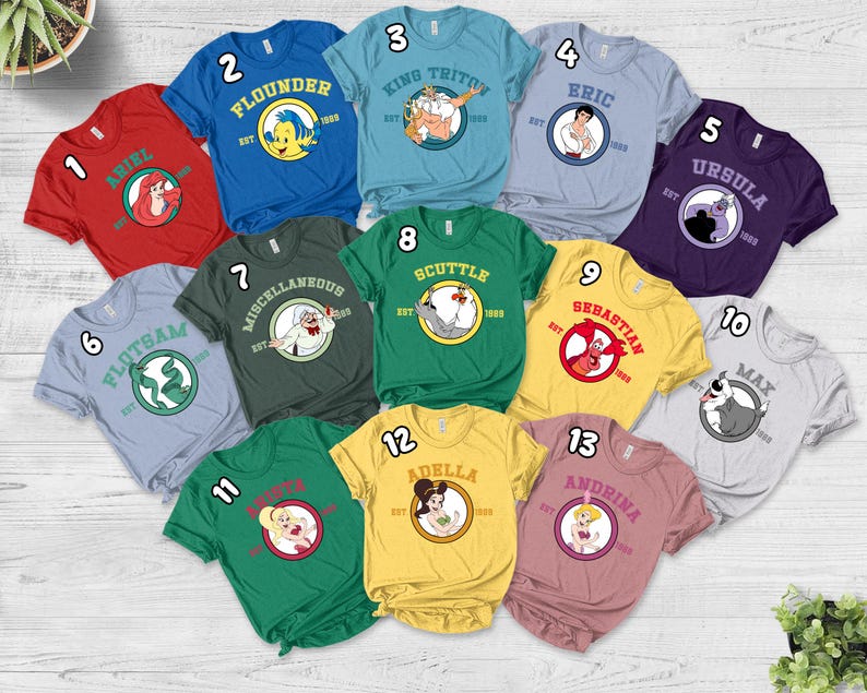 Puede incluir: Una colecci&oacute;n de camisetas coloridas con personajes de una popular pel&iacute;cula animada. Cada camiseta muestra el nombre y la imagen de un personaje dentro de un dise&ntilde;o circular. Las camisetas son de varios colores, incluyendo rojo, azul, verde y amarillo.