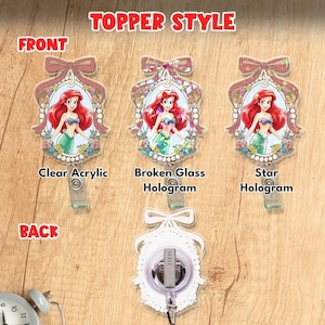 Puede incluir: Tres portatarjetas con Ariel la sirenita en un marco ovalado con lazo. Las etiquetas identifican los estilos como Clear Acrylic, Broken Glass Hologram y Star Hologram. Un cuarto muestra la parte trasera con clip. El texto dice TOPPER STYLE.