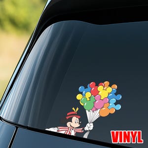May include: A colorful vinyl decal featuring Mickey Mouse holding a bouquet of Mickey Mouse-shaped balloons. The balloons are in various colors, including red, blue, yellow, green, pink, and orange. The word "VINYL" is in red block letters.