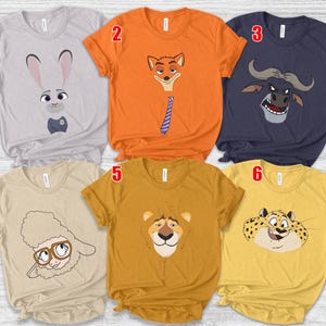May include: Six short-sleeved t-shirts with cartoon animal faces. The shirts are light gray, orange, navy blue, tan, mustard yellow, and gold. The animal faces include a rabbit, fox, buffalo, sheep, lion, and leopard.