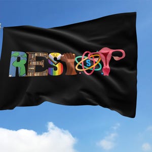 May include: Black flag waving in the wind against a blue sky. The flag features the word "RESIST" in colorful letters and symbols, including a rainbow, a fist, and a uterus graphic. The flag is attached to a silver pole.