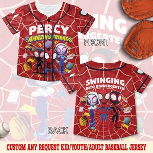 May include: A red baseball jersey with a spiderweb pattern, featuring the text PERCY AND HIS AMAZING FRIENDS on the front and SWINGING INTO KINDERGARTEN on the back. The design includes cartoon characters, school supplies, and black buttons.