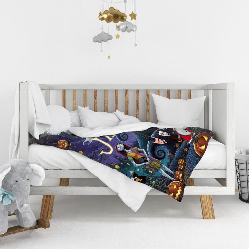 K&ouml;nnte beinhalten: Eine Pl&uuml;schdecke mit einem farbenfrohen Grafikdruck von Charakteren aus Nightmare Before Christmas, darunter Sally und Jack Skellington, vor einer dunkelvioletten und blauen Landschaft mit orangefarbenen K&uuml;rbissen.
