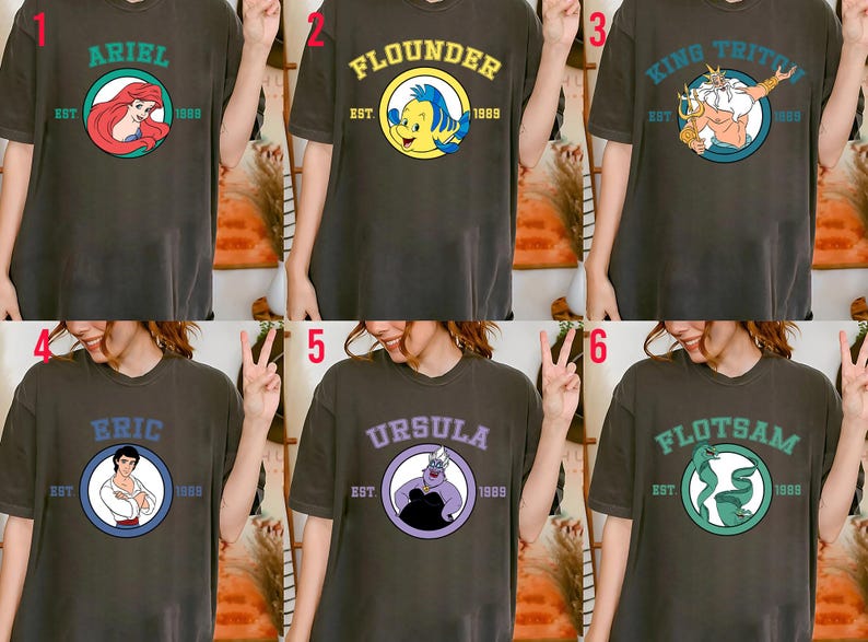 Puede incluir: Seis camisetas de color gris oscuro con dise&ntilde;os de personajes de dibujos animados. Cada camiseta tiene un nombre de personaje diferente en un c&iacute;rculo, como "Ariel" y "Flounder", con "EST. 1989" debajo. Las camisetas son usadas por una persona.